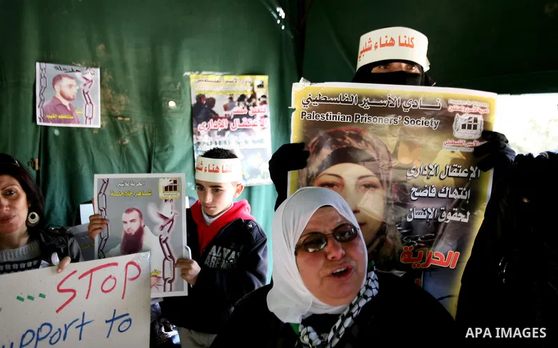 Palestinians hold portraits of jailed compatriots as they join a protest in solidarity with Hana Shalabi, a female Palestinian prisoner jailed in Israel who has been on hunger strike for 19 days, in the West Bank city of...