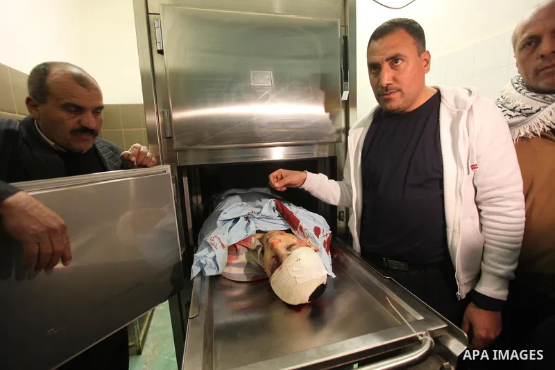 Relatives contemplate the dead body of Zakarya Abu Eram, who was shot dead by an Israeli soldier during an Israeli military operation in the village of Yatta, south of the West Bank town of Hebron, 08 March 2012. An Isra...
