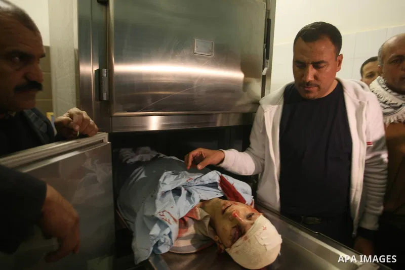 Relatives contemplate the dead body of Zakarya Abu Eram, who was shot dead by an Israeli soldier during an Israeli military operation in the village of Yatta, south of the West Bank town of Hebron, 08 March 2012. An Isra...