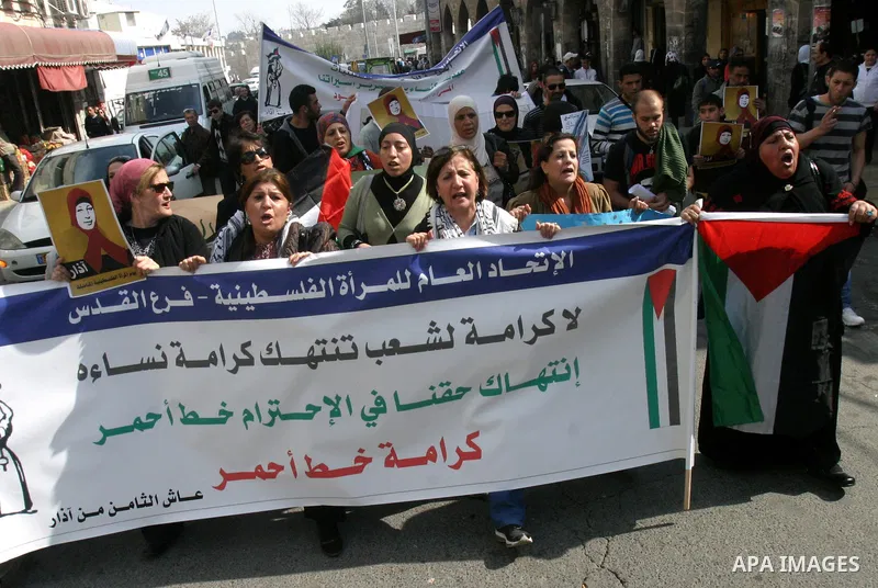 Women, holding Palestinian flags, shout slogans for the release of Hanaa al-Shalabi, a Palestinian woman freed in a prisoner swap with Israel but was re-arrested on February 16 2012, and has gone on hunger strike since,...