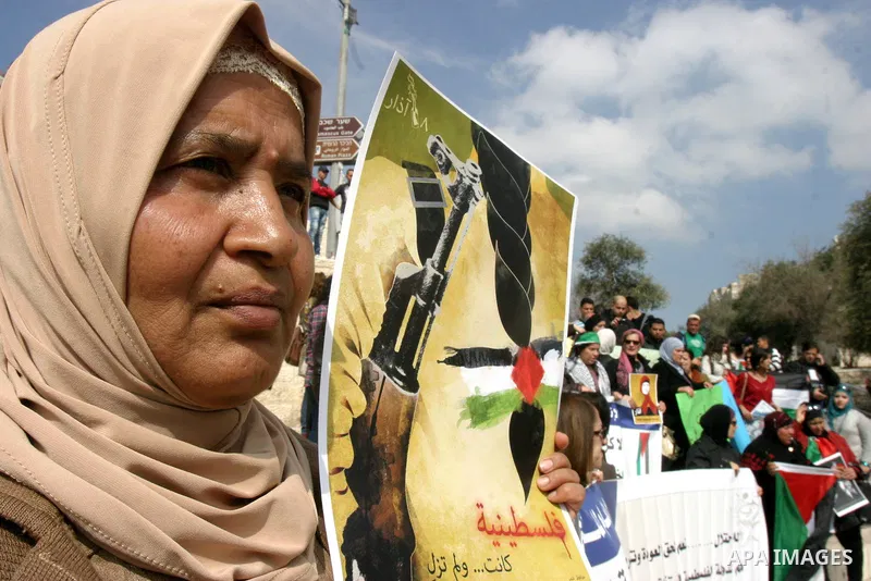 Women, holding Palestinian flags, shout slogans for the release of Hanaa al-Shalabi, a Palestinian woman freed in a prisoner swap with Israel but was re-arrested on February 16 2012, and has gone on hunger strike since,...