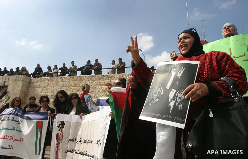 Women, holding Palestinian flags, shout slogans for the release of Hanaa al-Shalabi, a Palestinian woman freed in a prisoner swap with Israel but was re-arrested on February 16 2012, and has gone on hunger strike since,...