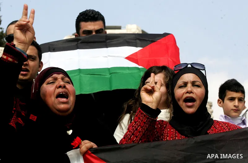 Women, holding Palestinian flags, shout slogans for the release of Hanaa al-Shalabi, a Palestinian woman freed in a prisoner swap with Israel but was re-arrested on February 16 2012, and has gone on hunger strike since,...