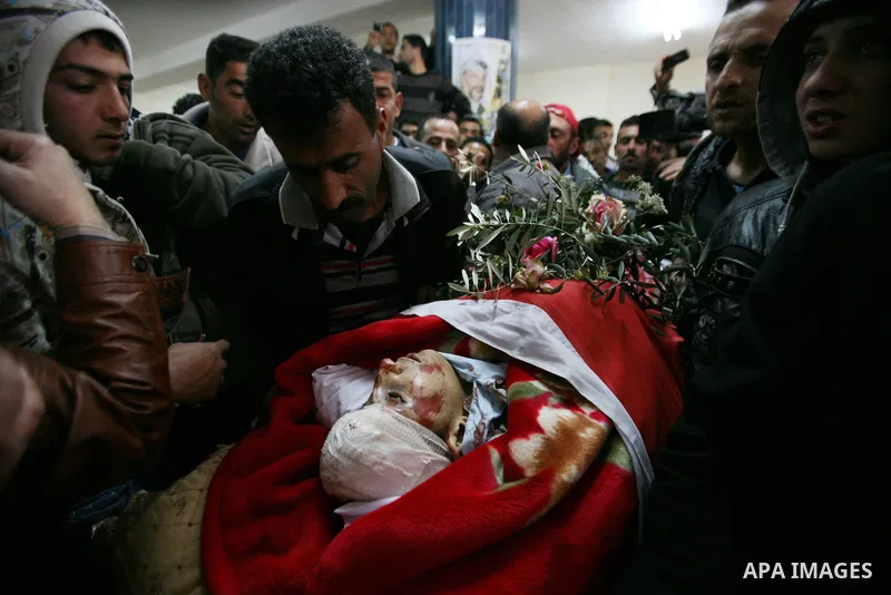 Palestinians looks the body of Zakariya Abu Eram during his funeral in the West Bank town of Yatta, near Hebron, Friday, March 9, 2012. According to the Israeli military, a Palestinian stabbed an Israeli soldier in the n...