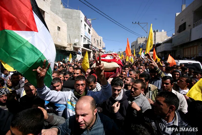 Palestinians carry the body of Zakariya Abu Eram during his funeral in the West Bank town of Yatta, near Hebron, Friday, March 9, 2012. According to the Israeli military, a Palestinian stabbed an Israeli soldier in the n...