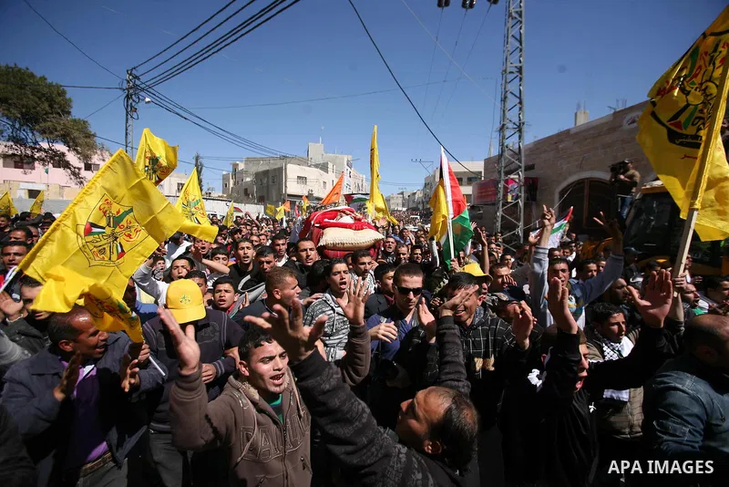 Palestinians carry the body of Zakariya Abu Eram during his funeral in the West Bank town of Yatta, near Hebron, Friday, March 9, 2012. According to the Israeli military, a Palestinian stabbed an Israeli soldier in the n...