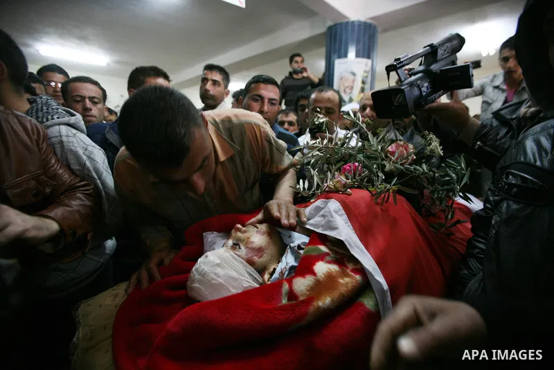 Palestinians looks the body of Zakariya Abu Eram during his funeral in the West Bank town of Yatta, near Hebron, Friday, March 9, 2012. According to the Israeli military, a Palestinian stabbed an Israeli soldier in the n...