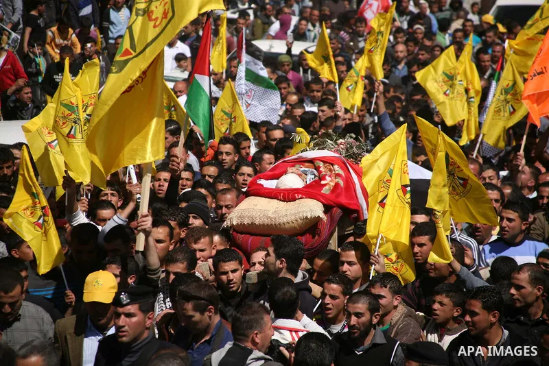 Palestinians carry the body of Zakariya Abu Eram during his funeral in the West Bank town of Yatta, near Hebron, Friday, March 9, 2012. According to the Israeli military, a Palestinian stabbed an Israeli soldier in the n...