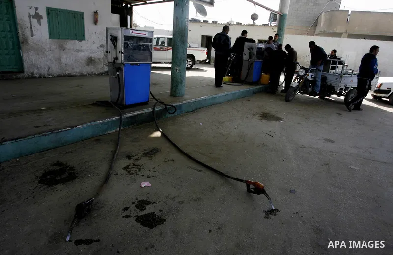 Palestinians wait to fill containers with fuel at a petrol station in Khan Younis in the southern Gaza Strip March 8, 2012. Palestinian Islamist group Hamas faces growing discontent in its Gaza stronghold because of rene...