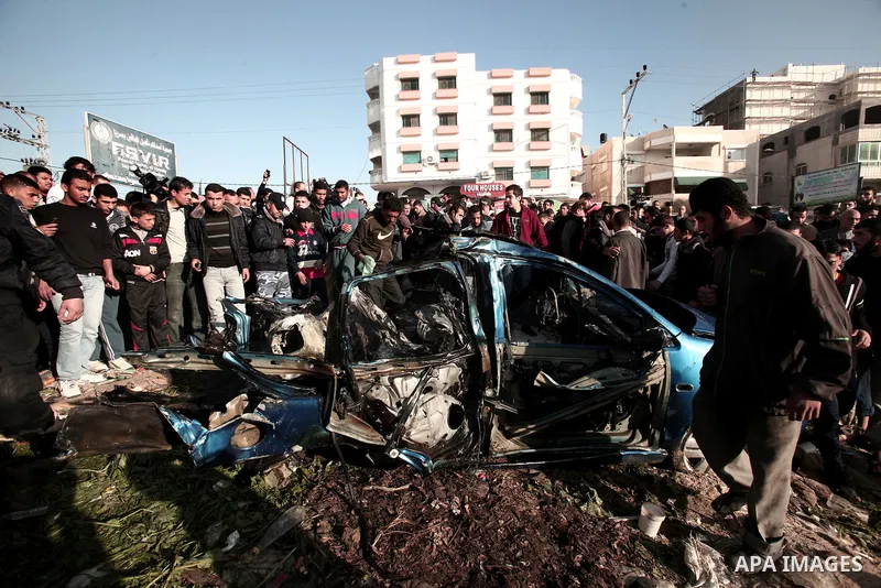 Palestinians look at the remains of a vehicle after it exploded in Gaza City March 9, 2012. Israel killed the leader of a Palestinian militant faction on Friday in a targeted attack on the car in the Gaza Strip, an Israe...