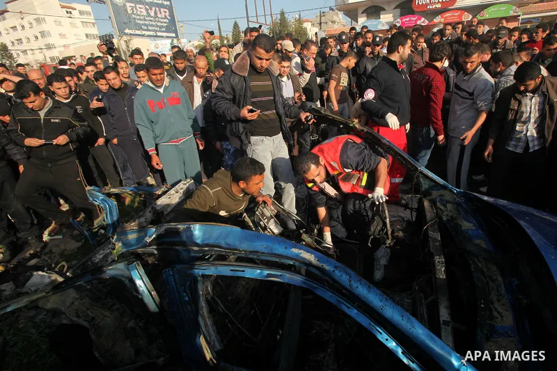 Palestinians look at the remains of a vehicle after it exploded in Gaza City March 9, 2012. Israel killed the leader of a Palestinian militant faction on Friday in a targeted attack on the car in the Gaza Strip, an Israe...