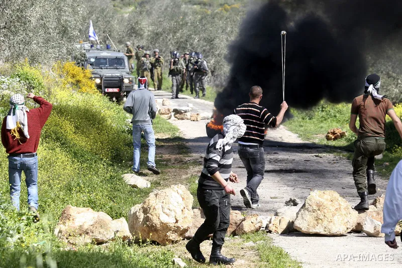 Palestinian youths hurlsl stones at Israeli security forces during a protest in the village of Kufr Qaddum near the Israeli settlement of Kdumim, in the northern West Bank, Friday, March 9, 2012. Photo by Wagdi Eshtayah
