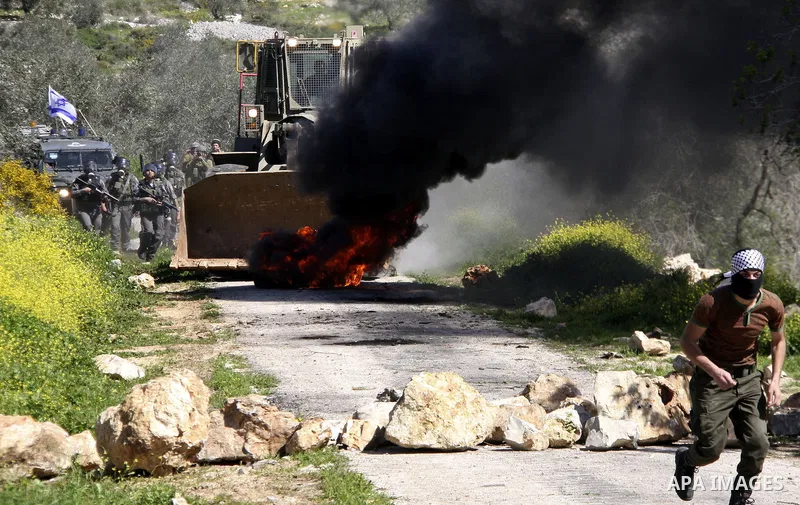 Palestinian youths hurlsl stones at Israeli security forces during a protest in the village of Kufr Qaddum near the Israeli settlement of Kdumim, in the northern West Bank, Friday, March 9, 2012. Photo by Wagdi Eshtayah