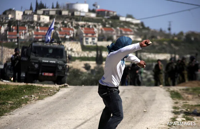 Palestinian youths hurlsl stones at Israeli security forces during a protest in the village of Kufr Qaddum near the Israeli settlement of Kdumim, in the northern West Bank, Friday, March 9, 2012. Photo by Wagdi Eshtayah