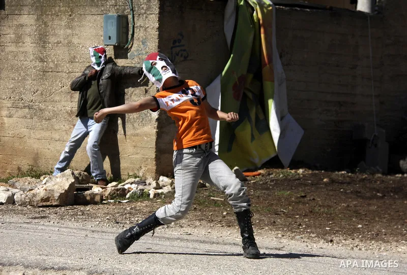 Palestinian youths hurlsl stones at Israeli security forces during a protest in the village of Kufr Qaddum near the Israeli settlement of Kdumim, in the northern West Bank, Friday, March 9, 2012. Photo by Wagdi Eshtayah