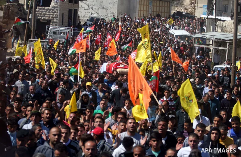 Palestinians carry the body of Zakariya Abu Eram during his funeral in the West Bank town of Yatta, near Hebron, Friday, March 9, 2012. According to the Israeli military, a Palestinian stabbed an Israeli soldier in the n...