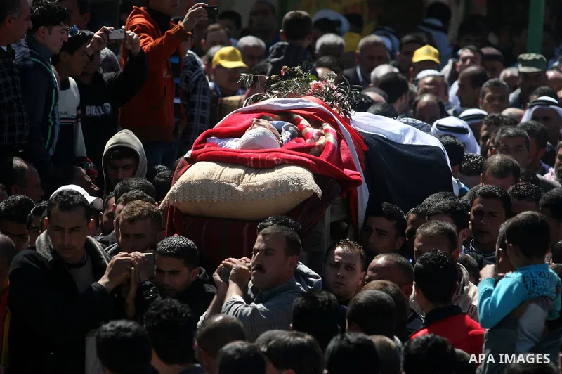 Palestinians carry the body of Zakariya Abu Eram during his funeral in the West Bank town of Yatta, near Hebron, Friday, March 9, 2012. According to the Israeli military, a Palestinian stabbed an Israeli soldier in the n...