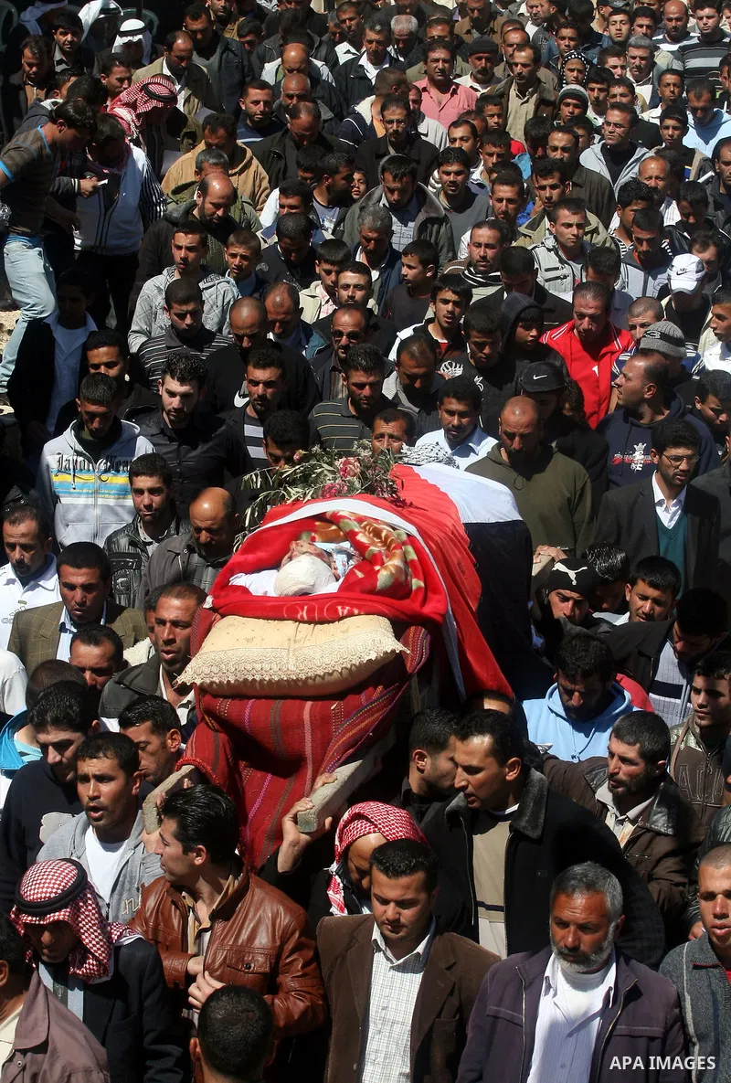 Palestinians carry the body of Zakariya Abu Eram during his funeral in the West Bank town of Yatta, near Hebron, Friday, March 9, 2012. According to the Israeli military, a Palestinian stabbed an Israeli soldier in the n...