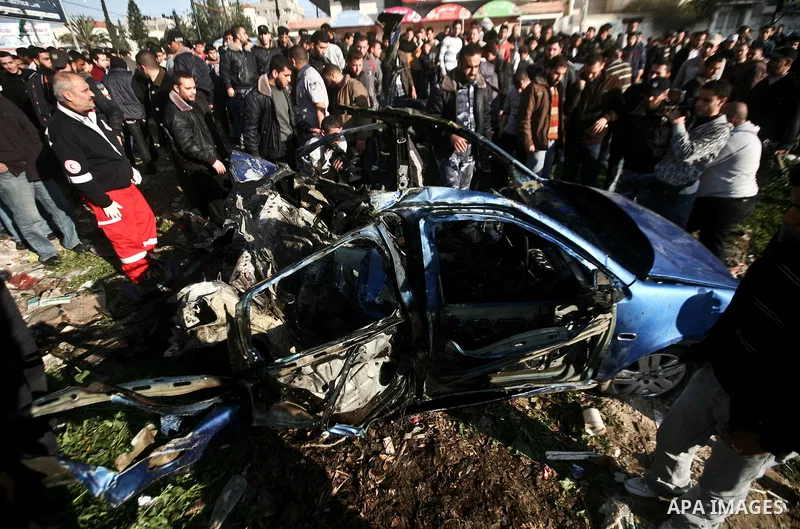 Palestinians look at the remains of a vehicle after it exploded in Gaza City March 9, 2012. Israel killed the leader of a Palestinian militant faction on Friday in a targeted attack on the car in the Gaza Strip, an Israe...