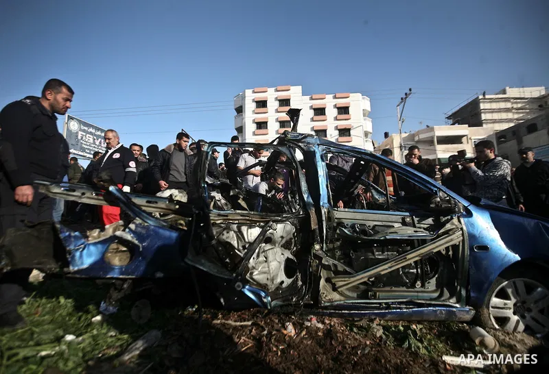 Palestinians look at the remains of a vehicle after it exploded in Gaza City March 9, 2012. Israel killed the leader of a Palestinian militant faction on Friday in a targeted attack on the car in the Gaza Strip, an Israe...
