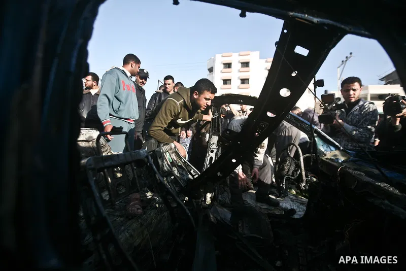 Palestinians look at the remains of a vehicle after it exploded in Gaza City March 9, 2012. Israel killed the leader of a Palestinian militant faction on Friday in a targeted attack on the car in the Gaza Strip, an Israe...