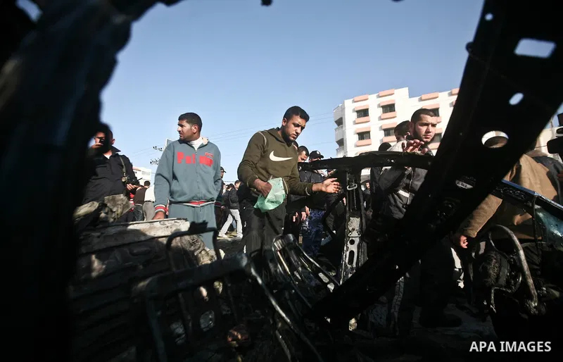 Palestinians look at the remains of a vehicle after it exploded in Gaza City March 9, 2012. Israel killed the leader of a Palestinian militant faction on Friday in a targeted attack on the car in the Gaza Strip, an Israe...