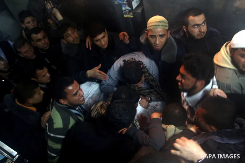 Palestinians mourn in a hospital over the body of one of two militants of the Al Quds Brigades, the military arm of Islamic Jihad, after they were killed in a second Israeli air strike in Gaza City on March 9, 2012, brin...
