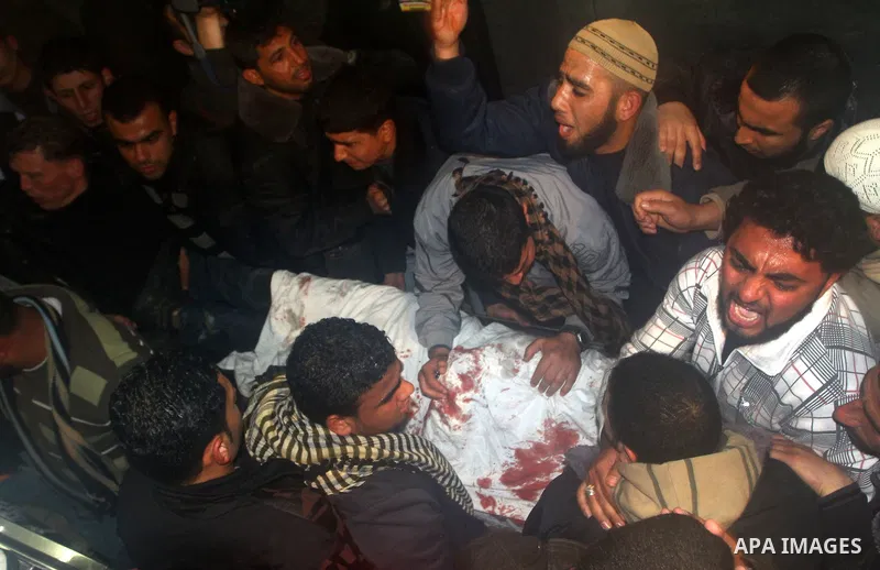 Palestinians mourn in a hospital over the body of one of two militants of the Al Quds Brigades, the military arm of Islamic Jihad, after they were killed in a second Israeli air strike in Gaza City on March 9, 2012, brin...