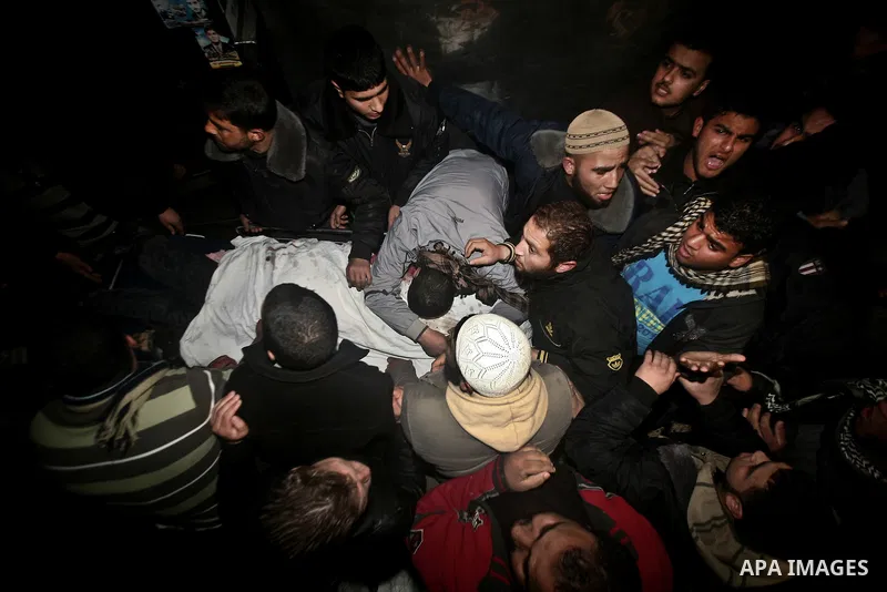 Palestinians mourn in a hospital over the body of one of two militants of the Al Quds Brigades, the military arm of Islamic Jihad, after they were killed in a second Israeli air strike in Gaza City on March 9, 2012, brin...