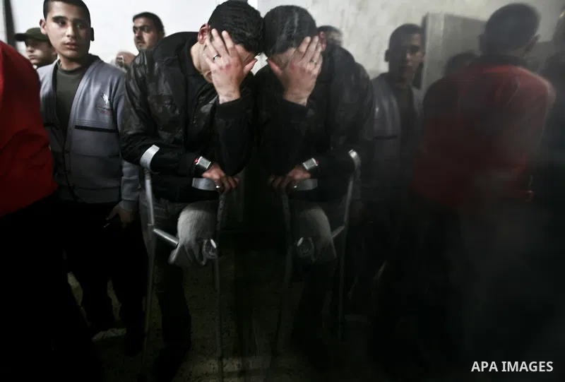 A Palestinian man mourns in a hospital after two militants of the Al Quds Brigades, the military arm of Islamic Jihad, were killed in a second Israeli air strike in Gaza City on March 9, 2012, bringing the number of Pale...