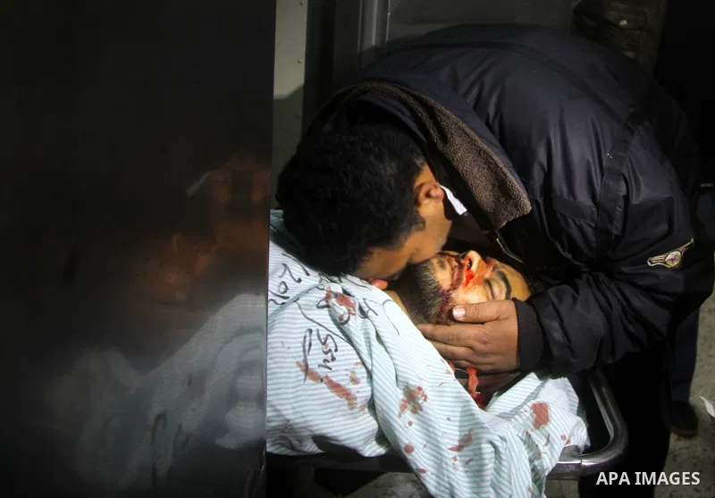Palestinians mourn in a hospital over the body of one of two militants of the Al Quds Brigades, the military arm of Islamic Jihad, after they were killed in a second Israeli air strike in Gaza City on March 9, 2012, brin...