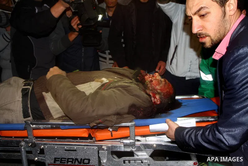 Palestinians mourn in a hospital over the body of one of two militants of the Al Quds Brigades, the military arm of Islamic Jihad, after they were killed in a second Israeli air strike in Gaza City on March 9, 2012, brin...