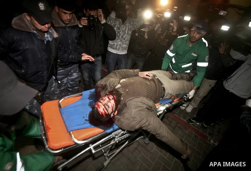 Palestinians mourn in a hospital over the body of one of two militants of the Al Quds Brigades, the military arm of Islamic Jihad, after they were killed in a second Israeli air strike in Gaza City on March 9, 2012, brin...