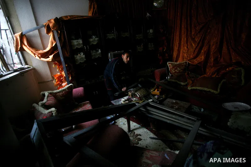 Palestinians inspect damage in their house in Al Shijaia Neighborhood in Gaza city, after an Israeli air strike in Gaza City on 10 March 2012, bringing the number of Palestinians killed in a day of cross-border fighting...