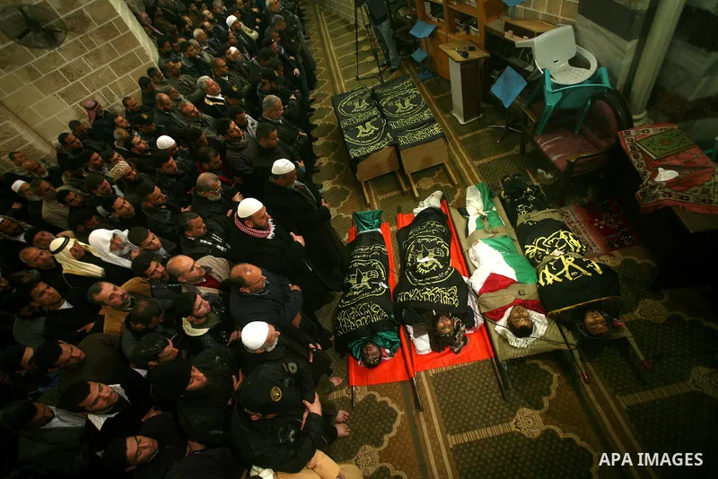 Palestinians pray near the bodies of Islamic Jihad militants during their funeral in Gaza March 10, 2012. Israel killed two more Gaza militants on Saturday, raising the death toll in two days of violence to 12 and dozens...