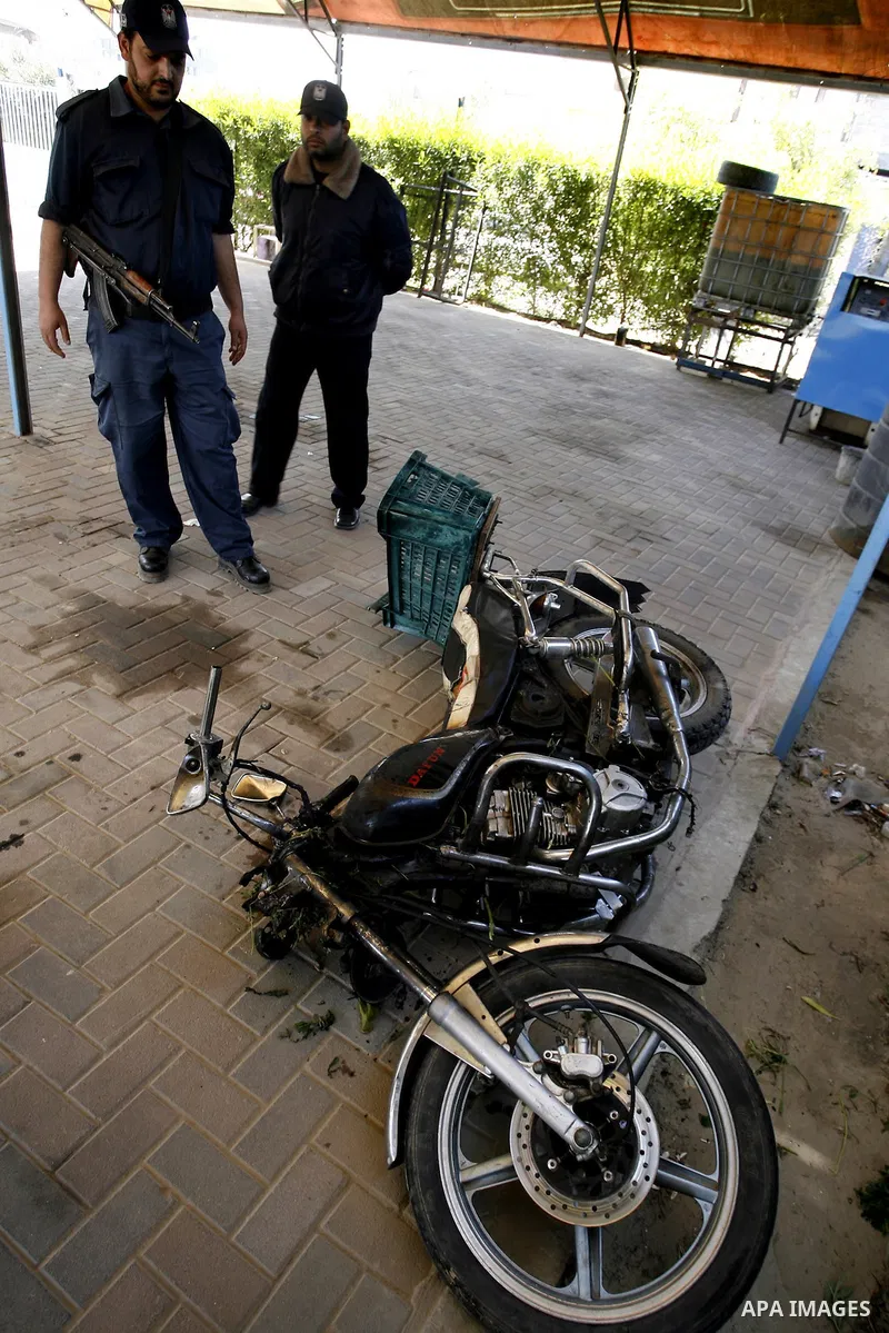 Palestinians inspect a motorcycle that was hit in an Israeli air strike in Khan Younis in the southern Gaza Strip March 10, 2012. Israel killed four Gaza militants on Saturday as violence sparked by the death of a milita...