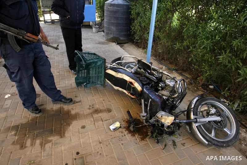 Palestinians inspect a motorcycle that was hit in an Israeli air strike in Khan Younis in the southern Gaza Strip March 10, 2012. Israel killed four Gaza militants on Saturday as violence sparked by the death of a milita...