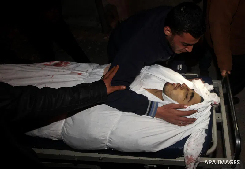 Relatives of Ahmed salem, 22-year-old, look at his body in the morgue of Al-Shifa hospital in Gaza City, on March 11, 2012, following a fresh Israeli air raid, bringing the death toll from strikes since March 10 to 17 an...