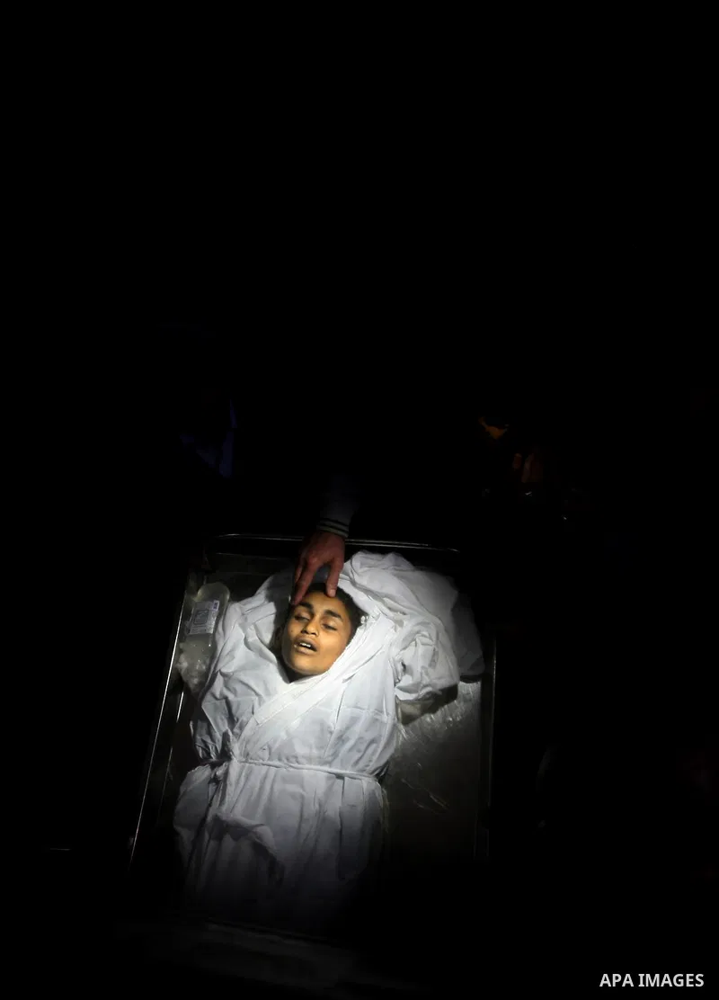Relatives of Ayoub Assalya, 12-year-old, look at his body in the morgue of Kamal Edwan hospital in Beit Lahia in the northern Gaza Strip, on March 11, 2012, following a fresh Israeli air raid, bringing the death toll fro...