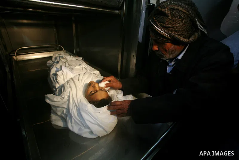 Relatives of Ayoub Assalya, 12-year-old, look at his body in the morgue of Kamal Edwan hospital in Beit Lahia in the northern Gaza Strip, on March 11, 2012, following a fresh Israeli air raid, bringing the death toll fro...