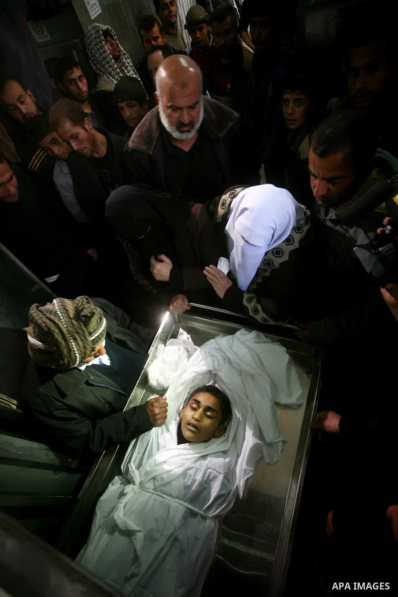 Relatives of Ayoub Assalya, 12-year-old, look at his body in the morgue of Kamal Edwan hospital in Beit Lahia in the northern Gaza Strip, on March 11, 2012, following a fresh Israeli air raid, bringing the death toll fro...
