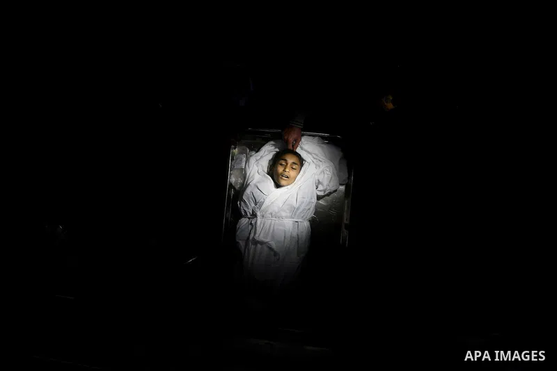 Relatives of Ayoub Assalya, 12-year-old, look at his body in the morgue of Kamal Edwan hospital in Beit Lahia in the northern Gaza Strip, on March 11, 2012, following a fresh Israeli air raid, bringing the death toll fro...