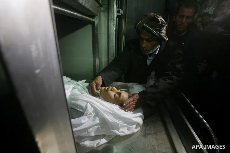 Relatives of Ayoub Assalya, 12-year-old, look at his body in the morgue of Kamal Edwan hospital in Beit Lahia in the northern Gaza Strip, on March 11, 2012, following a fresh Israeli air raid, bringing the death toll fro...