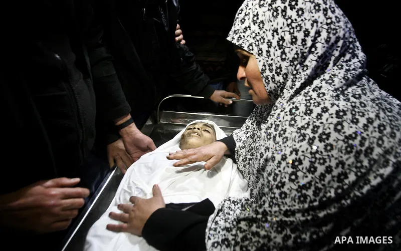The mother of Ayoub Asalya, 12-year-old, bids fare well to her son in the morgue of Kamal Edwan hospital in Beit Lahia in the northern Gaza Strip, on March 11, 2012, following a fresh Israeli air raid, bringing the death...