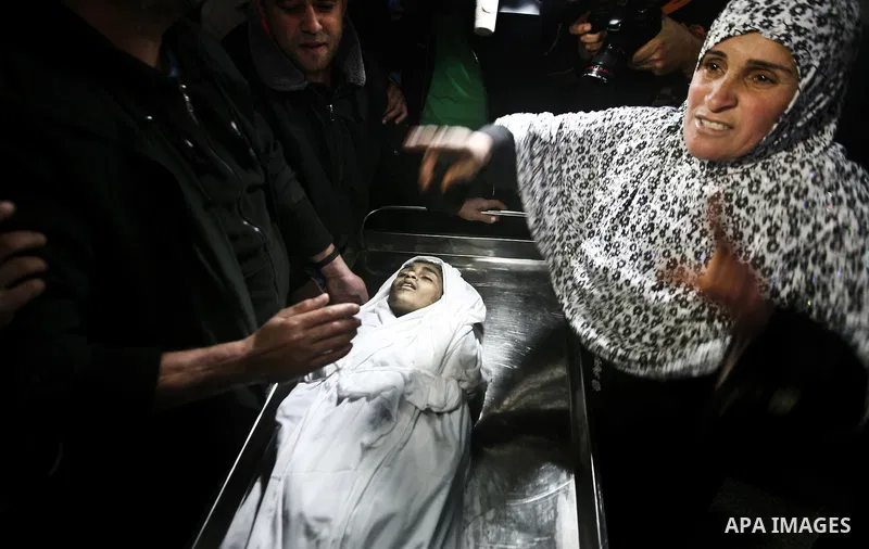 The mother of Ayoub Asalya, 12-year-old, bids fare well to her son in the morgue of Kamal Edwan hospital in Beit Lahia in the northern Gaza Strip, on March 11, 2012, following a fresh Israeli air raid, bringing the death...