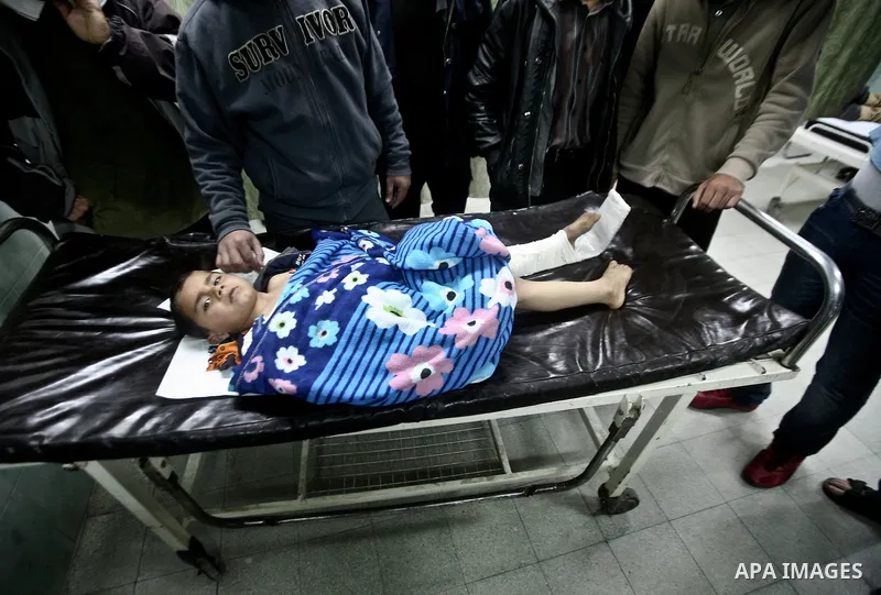 A wounded Palestinian child is checked by doctors at a hospital in Beit Lahia in the northern Gaza Strip, on March 11, 2012, following a fresh Israeli air raid, bringing the death toll from strikes since March 10 to 17 a...