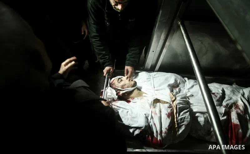 Relatives of Ahmed salem, 22-year-old, look at his body in the morgue of Al-Shifa hospital in Gaza City, on March 11, 2012, following a fresh Israeli air raid, bringing the death toll from strikes since March 10 to 17 an...