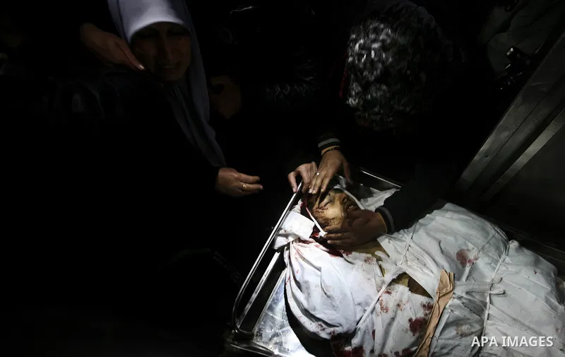 Relatives of Ahmed salem, 22-year-old, look at his body in the morgue of Al-Shifa hospital in Gaza City, on March 11, 2012, following a fresh Israeli air raid, bringing the death toll from strikes since March 10 to 17 an...