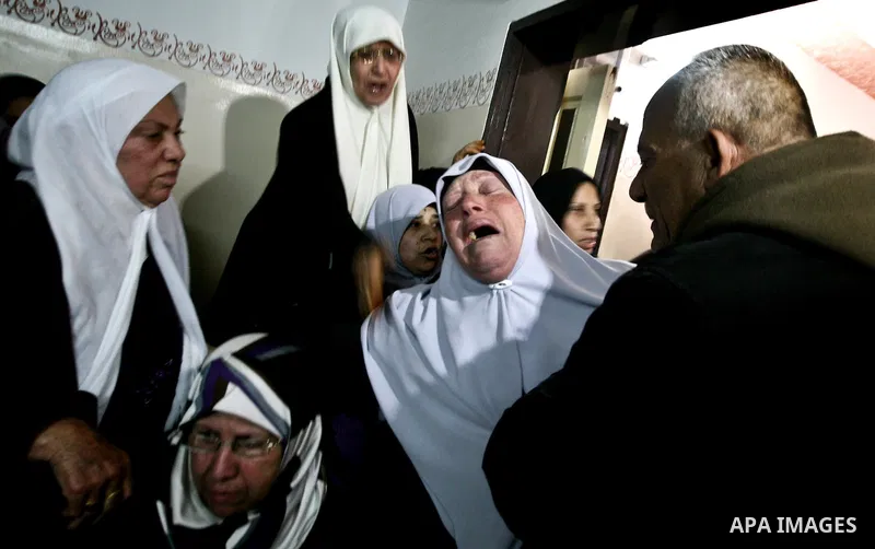 Palestinian relatives of Ahmed Salim, one of the Nasser Salah Addin Brigades who was killed in an Israeli air strike, mourn during his funeral in Gaza City,Sunday, March 11, 2012. Medics said Israeli air strikes on the G...