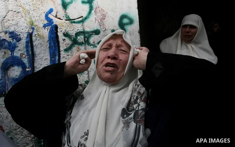 Palestinian relatives of Ahmed Salim, one of the Nasser Salah Addin Brigades who was killed in an Israeli air strike, mourn during his funeral in Gaza City,Sunday, March 11, 2012. Medics said Israeli air strikes on the G...